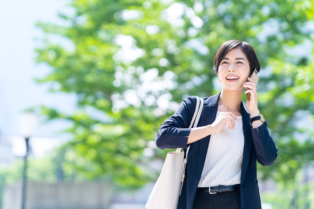 女性が電話しながら通勤しているイメージ