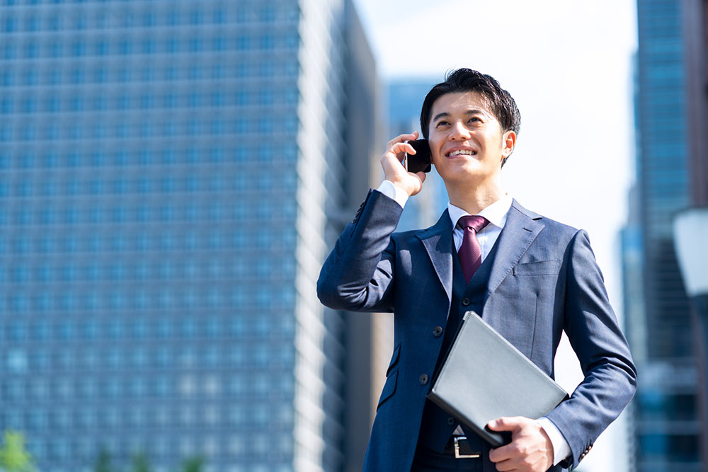 外で電話をする男性